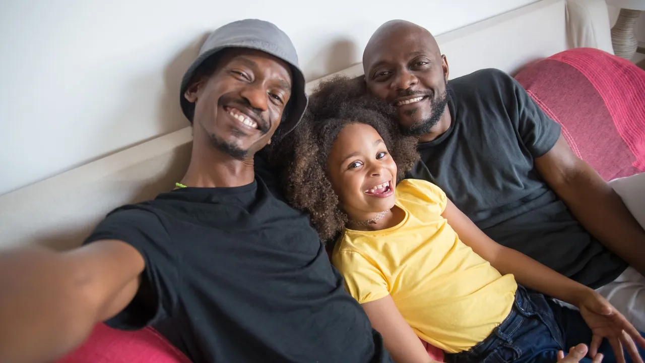 A family taking a selfie on the sofa after filing their taxes with Rapido Refunds