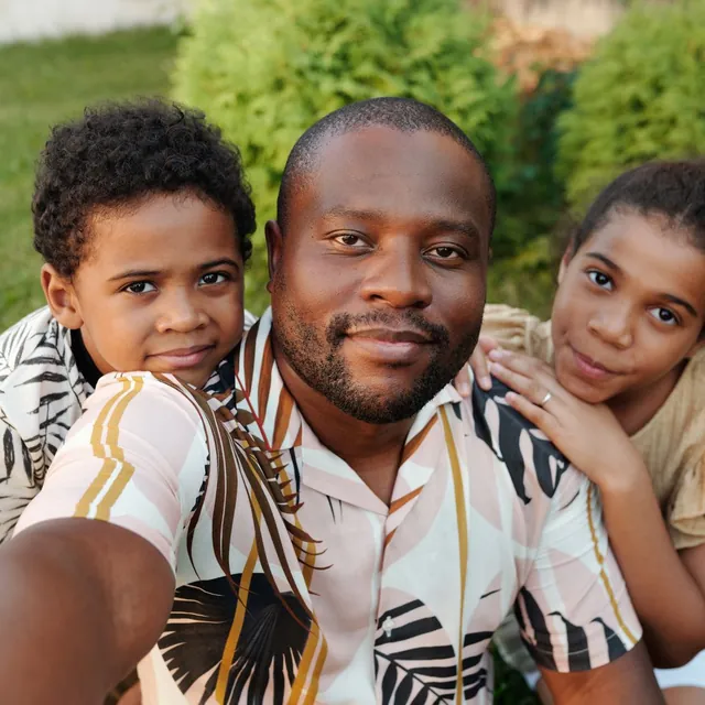 A father with his two children, part of the Far Rockaway community Rapido Refunds serves
