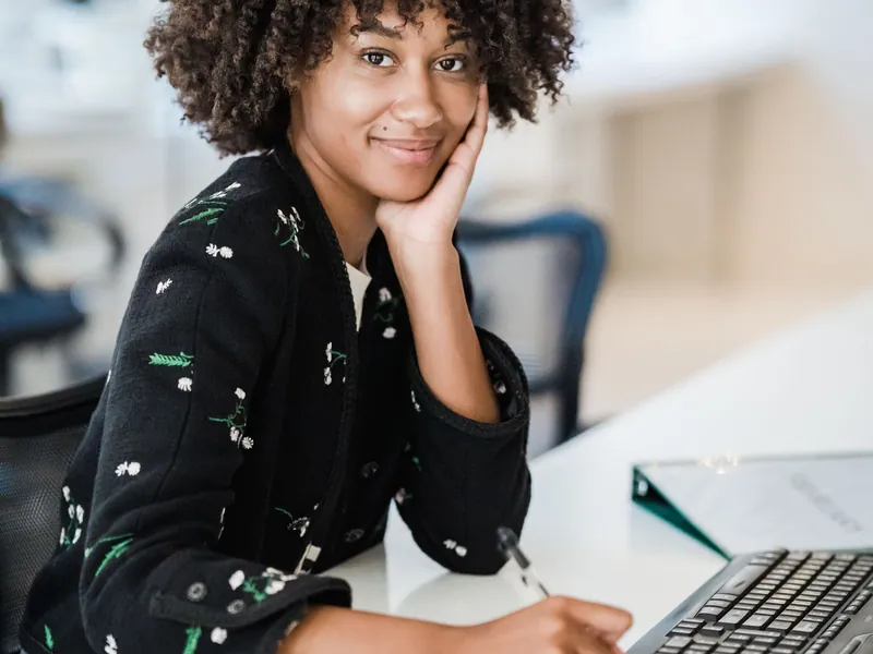 A trainee tax preparer smiling at her desk at Rapido Refunds