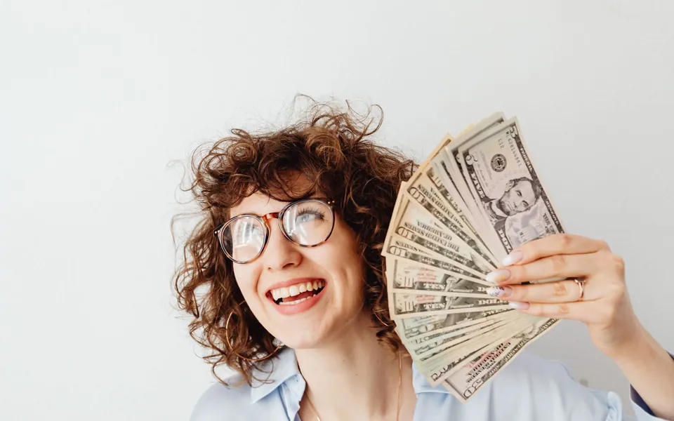 A smiling Rapido Refunds client holding the cash from her tax refund