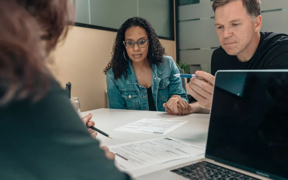 A Rapido Refunds preparer explaining the price of a tax return to a couple before starting