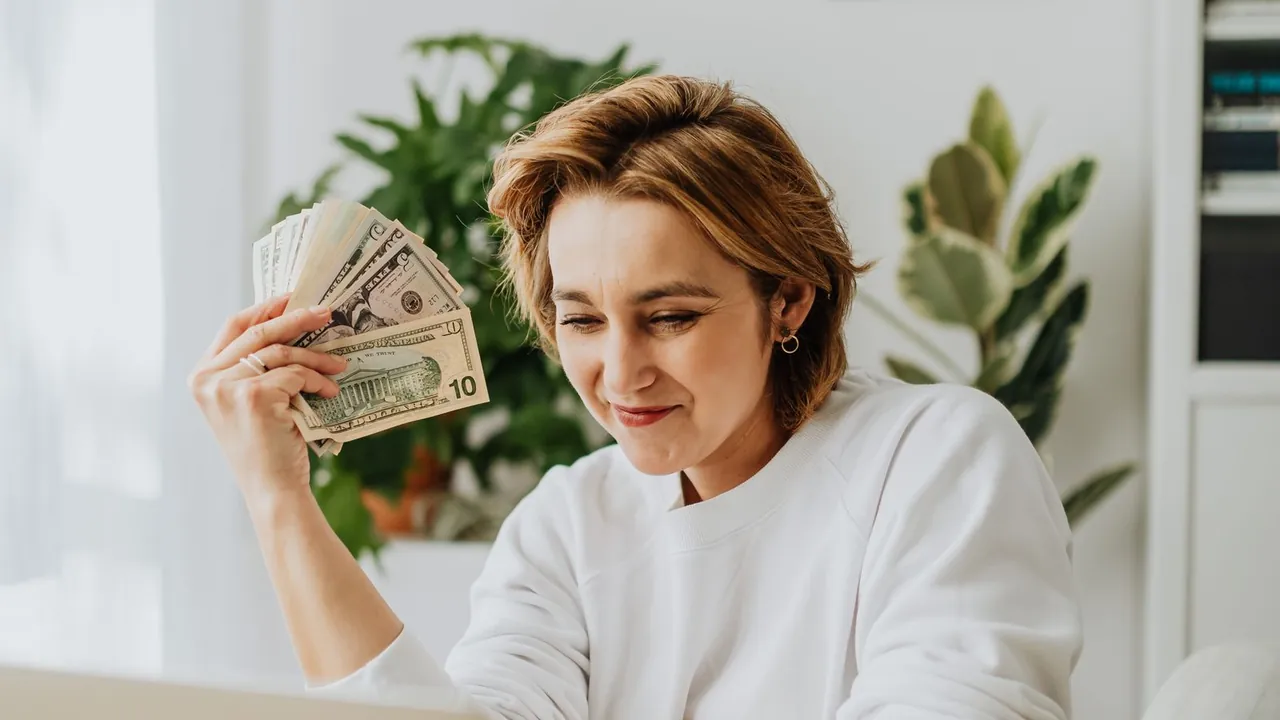 A Rapido Refunds client at her desk holding the refund she kept after paying nothing out of pocket